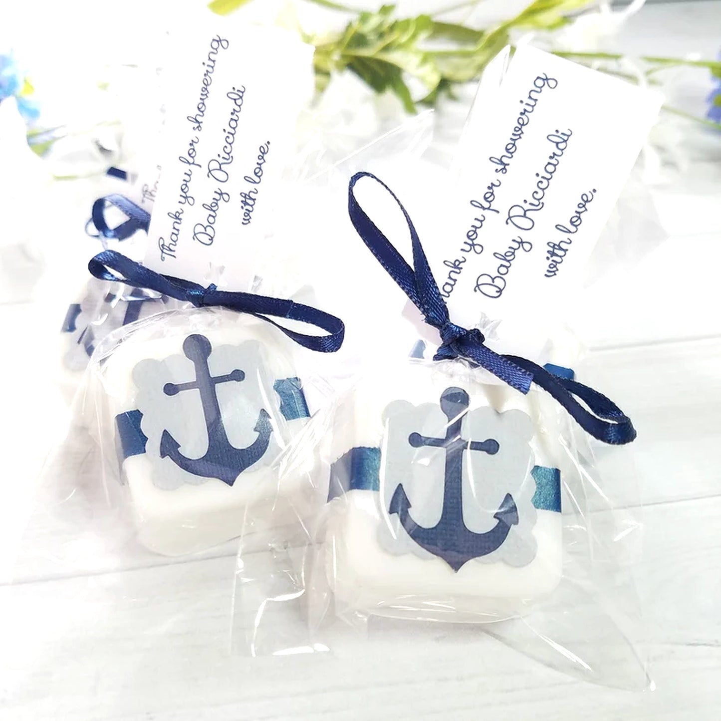 White Soap with blue anchor design in clear packages tied with blue ribbons on a white background.