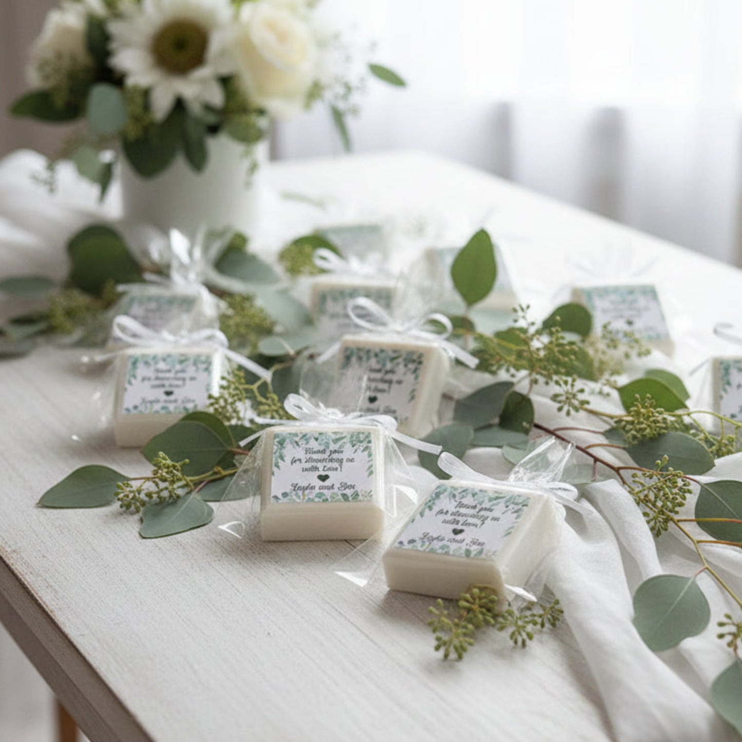 wrapped eucalyptus themed soap favors with personalized labels on a white surface