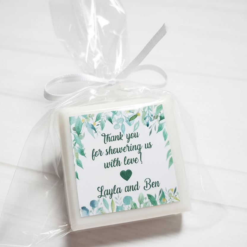 Gift bag with a decorative tag and white ribbon, featuring a floral design and text.